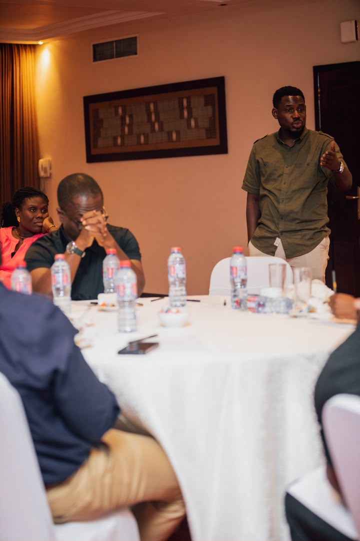 Dr. Asante-Darko addressing clients seated at a roundtable discussion